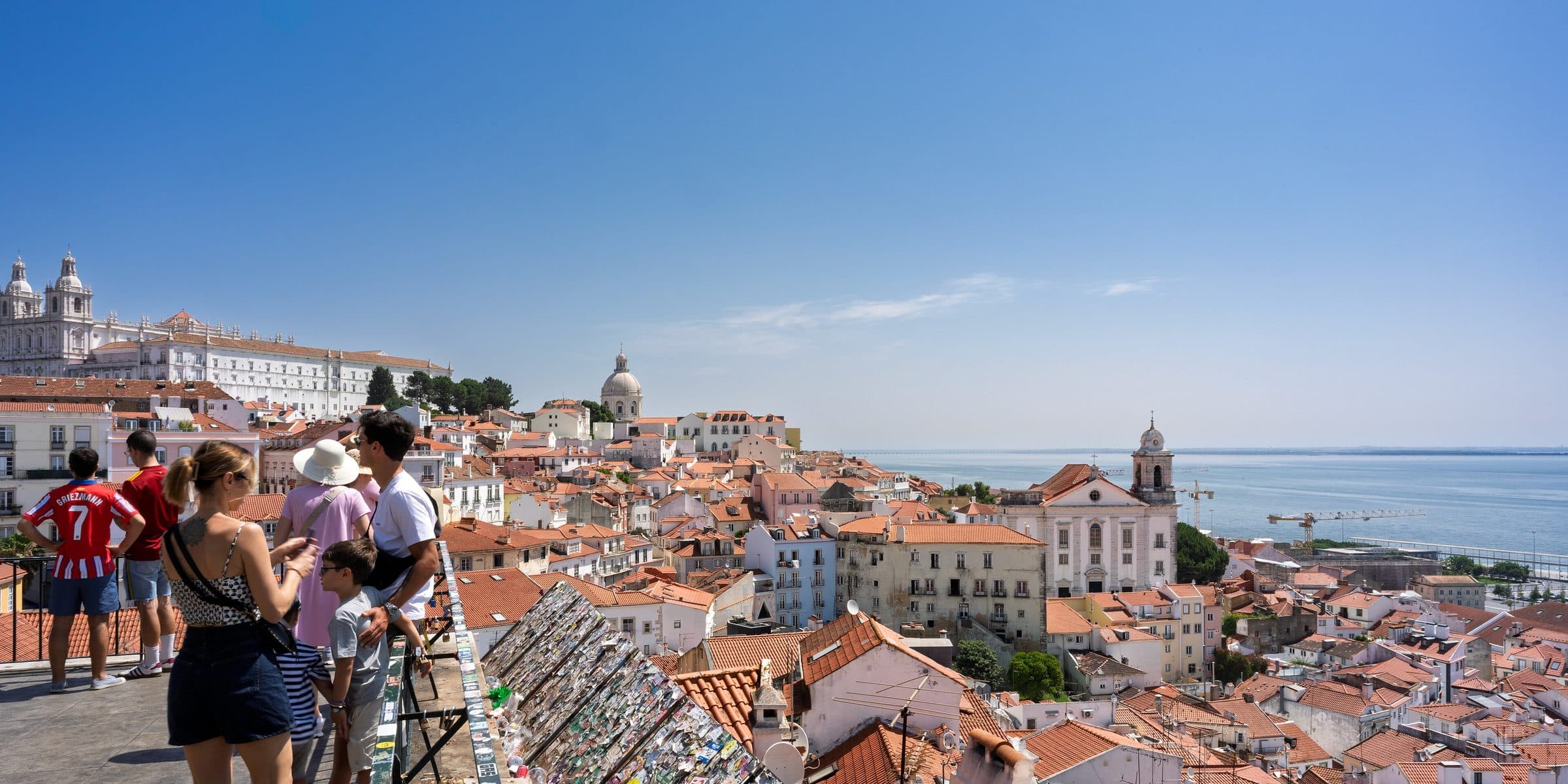 Terracotta rooftops of Lisbon's Alfama district sloping down to the Tagus