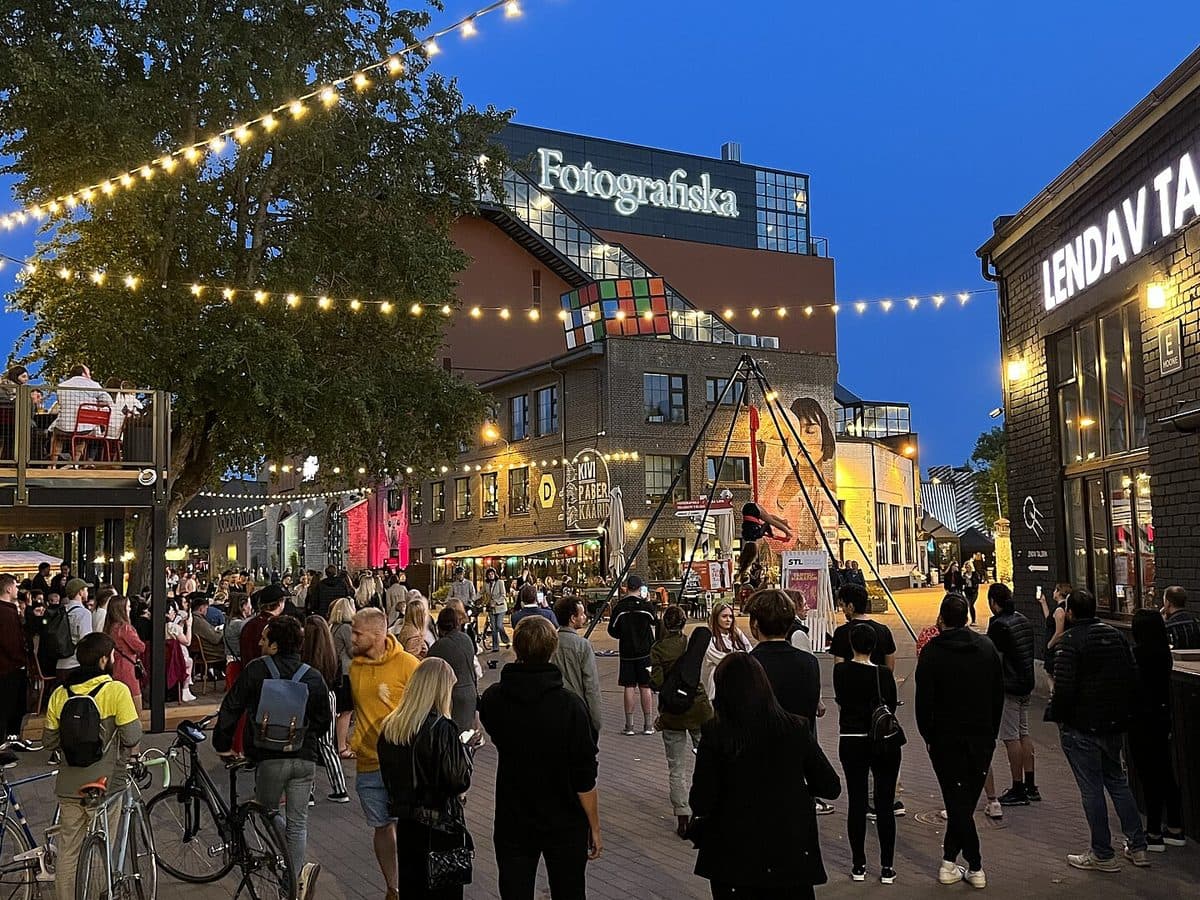 Evening crowds and festoon lighting between the warehouses of Telliskivi Creative City