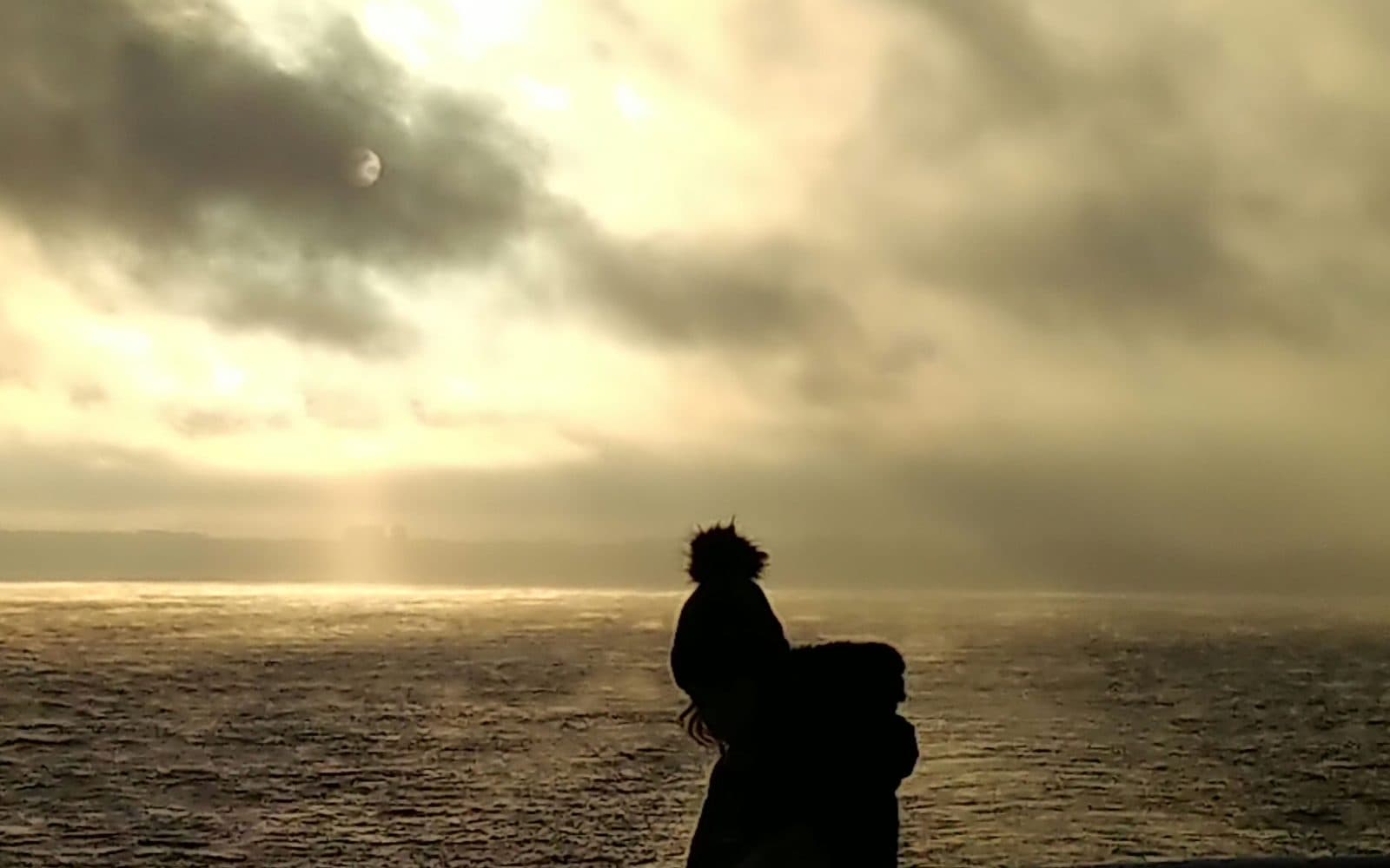 A figure silhouetted against the Baltic at sunset from a ferry deck